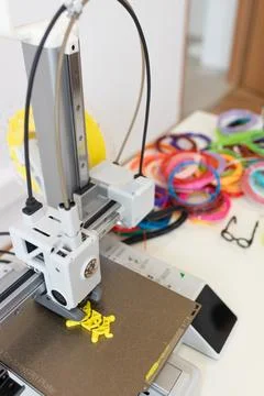 A 3D printer creates objects with colorful bands and innovative designs using Foto stock