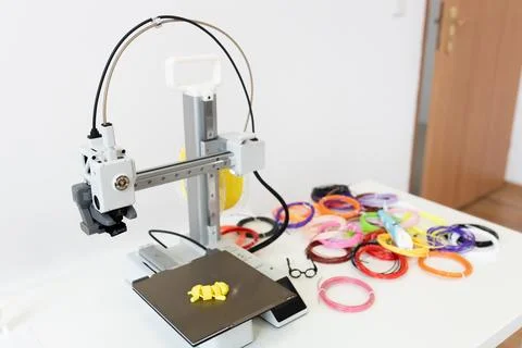 A 3D printer creates objects with colorful bands and innovative designs using Foto stock