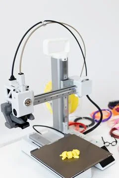 A 3D printer creates objects with colorful bands and innovative designs using Stock Photos