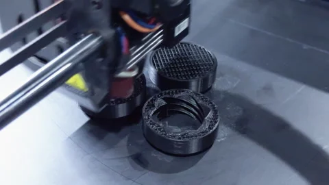 3d printer creating small black plastic prototypes layer by layer Stock Footage 318360473