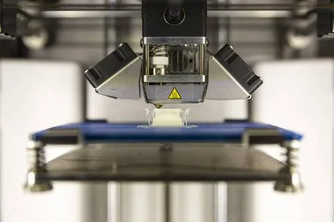 3D Printer detail A 3D printer prints a white plastic detail. Three dimens... Foto stock