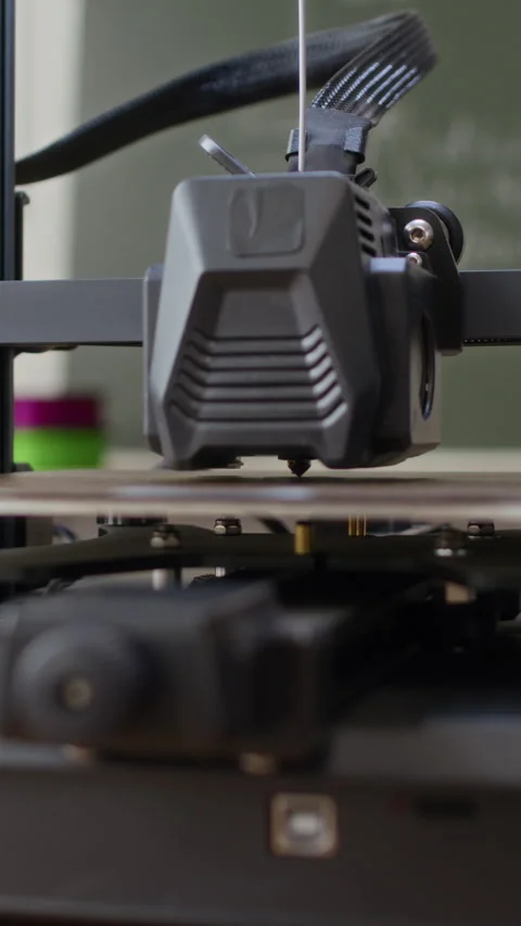 3D Printer Extruder Operating In Modern Classroom Stockbeeldmateriaal 335695144