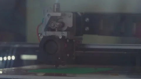 3D printer head prints plotting device on green plastic piece Stock Footage 78856184