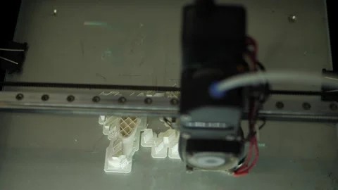 A 3D printer machine that creates a three-dimensional geometric shape. Stock Footage 311153872