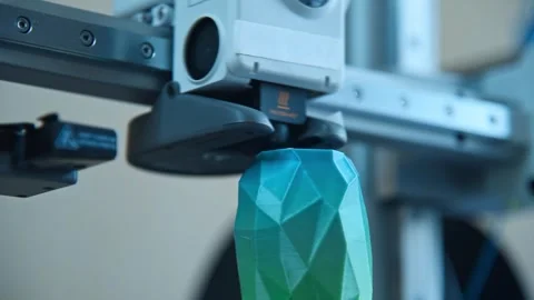 3D printer nozzle extruding plastic filament to create a geometric object. Stockbeeldmateriaal 336198935