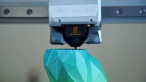 3D printer nozzle extruding plastic filament to create a geometric object. Stockbeeldmateriaal 336198954