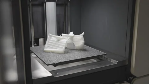 A 3D printer is in operation, creating a white object Stock Footage 301624638