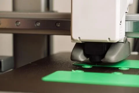 3D printer printing green plastic parts on build plate, close-up of additive Foto stock