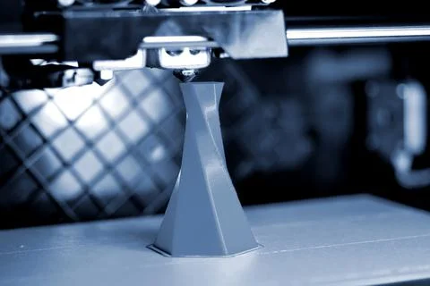 3D printer printing isolated volume triangular object blue gray color Stock Photos