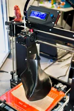 3D printer printing a model in the form of black vase close-up. Stock Photos