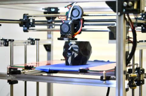 3D printer printing a model in the form of black skull close-up Foto stock