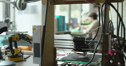 3D printer printing a prototype and engineering students Stock Footage 168339568