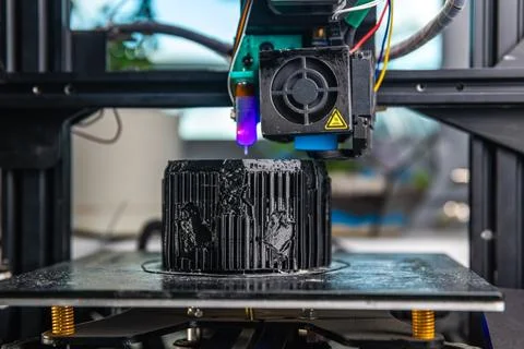 A 3D printer prints a black model. Technology at home Stock Photos