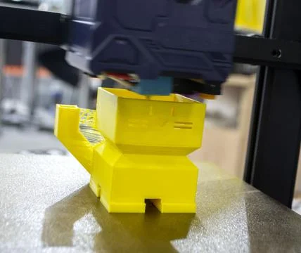 3D printer prints an object. The process of printing yellow model on 3D printer Stock Photos