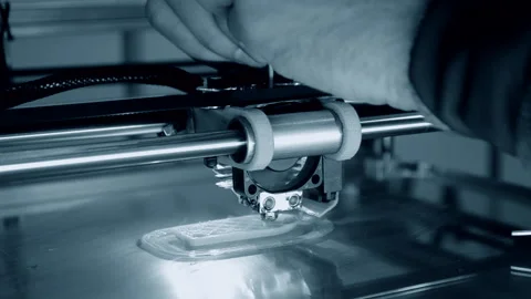 3d printer prints orange object close-up. Automatic three dimensional 3D printer Stock Footage 153058343