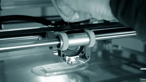3d printer prints orange object close-up. Automatic three dimensional 3D printer Stock Footage 153058666