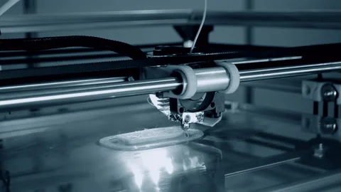 3d printer prints orange object close-up. Automatic three dimensional 3D printer Stock Footage 153058684