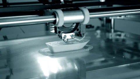 3d printer prints orange object close-up. Automatic three dimensional 3D printer Stock Footage 153058836