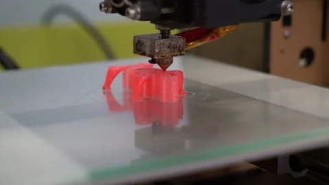 3D printer prints the part of the red polymer close-up Stock Footage 106525657