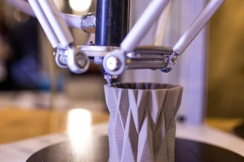 3d printer in the process of making a geometric vase. 3d printer during the p Stock Photos