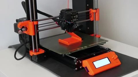 3D Printer Prusa i3 MK3S 3D printing an object using ABS orange filament Video stock 131273872