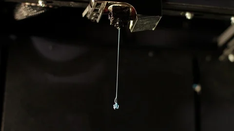 3D printer technology head prints red part from plastic cable thread close up. Stock Footage 124384645