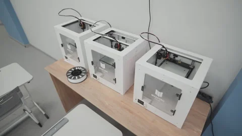 3D printers arranged in row on table in educational lab Видео 333211812