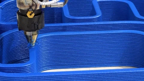 3D printing process creating intricate blue design in workshop setting during Stock Footage 312879513