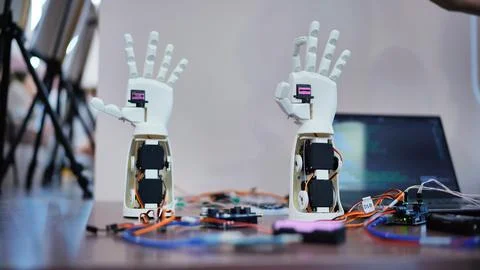 3D printing robot hand prototypes at a robotics exhibition, showcasing Stock Photos