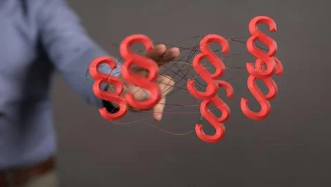 3D render of floating paragraph law and justice symbols near a lawyer's hand Stock Photos