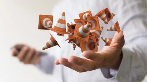 A 3D render of floating traffic cones over a businessman's hands- site constr 스톡 사진
