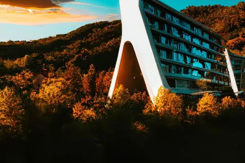 3D render of a futuristic modern triangular building design in rural mountains Ilustração Stock