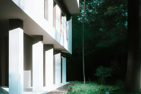 3D render of a futuristic stone house exterior with columns and nearby trees イラスト素材