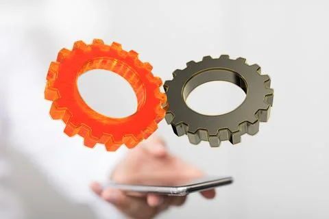 3D rendered gear icons hovering over a person's hand holding a smartphone Stock Photos