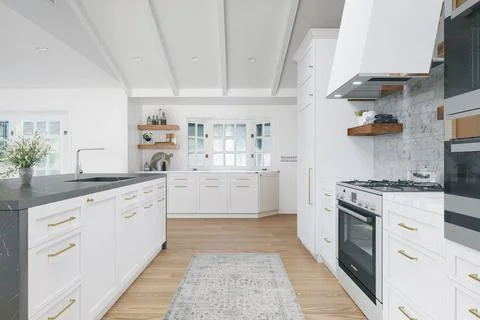3D-rendered view of a wide white kitchen - modern house interior design Stock Photos