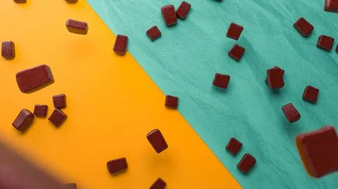 3D rendering of chocolate pieces on a yellow and blue background Illustrazione stock