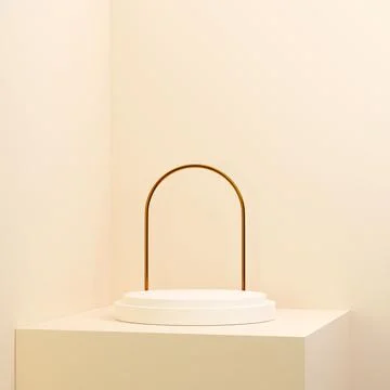 3D rendering of a golden arch behind a white round stand on light pink backgroun 스톡 일러스트