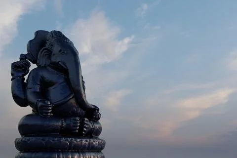 A 3D rendering of a Hindu black elephant statue with a cloudy sky in the back Stock Illustration