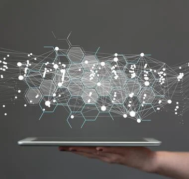 A 3D rendering hologram of a network of hexagons on a tabl against a gray bac Stock Photos