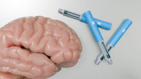 A 3d rendering of the human brain and injector pens. Ilustración de archivo