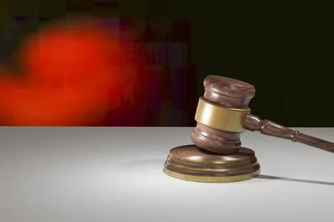 3d rendering of judgment hammer on white table with black and red background Stock Illustration