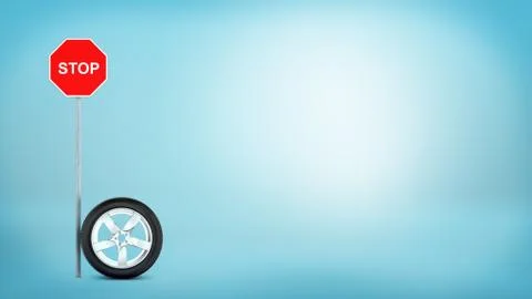 3d rendering of one car chrome wheel standing on its rim beside a 'STOP' red Stock Illustration