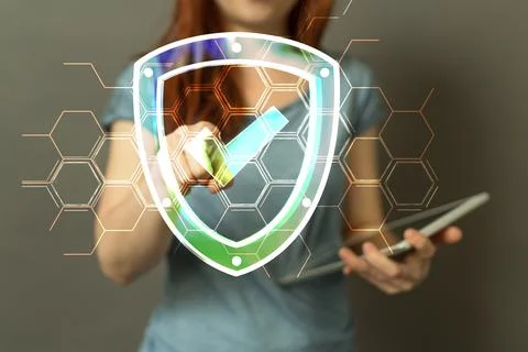 A 3D rendering of a security shield and woman using a tablet; cyber security  Stock Photos
