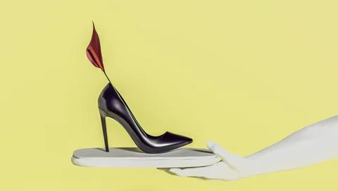 3d rendering of a woman's hand holding a woman's high heeled shoe with a flower. Stock Photos