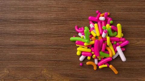 3D top view render of rainbow sprinkles on a wooden board Stock Illustration