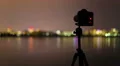 4 in 1 video! The camera and man with tripod stand by sunrise and lake with city 4k or 4k+ Resolution