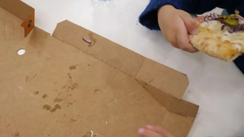 A 4-5 year old child's hand takes a piece of pizza from a box Stock Footage 287945498