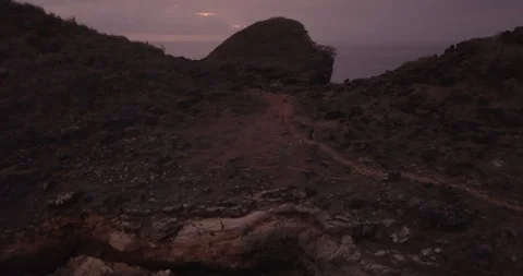 4. aerial view, bird view,a man climbs a hill near the sea with a rock in fro Stock Footage 121700379