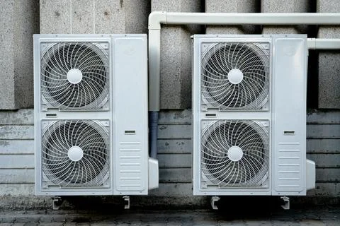 4 compressors installed on the outside wall of the building. Stock Photos