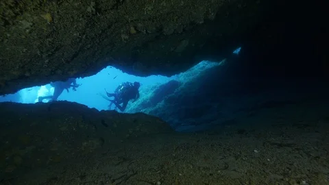 4 divers from a crack enter in a cave, Ustica, Sicily, Mediterranean sea Stock Footage 126656566